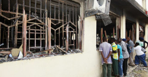 Residents peer into a building bombed by unidentified gunmen who attacked the coastal Kenyan town of Mpeketoni